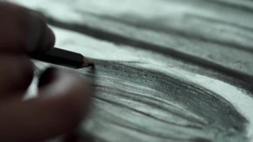 A person colors in a dark sketch