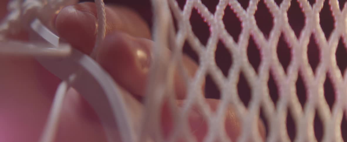 A man is lacing webbing to a frame
