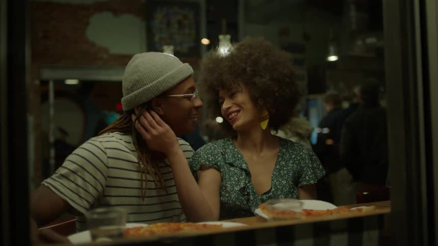 A man and woman dine and kiss in a restaurant