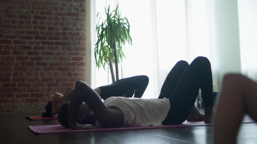 Women do a pose in a yoga class