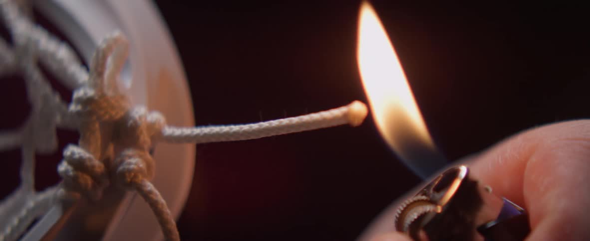 Flame from a lighter is applied to a cord tip