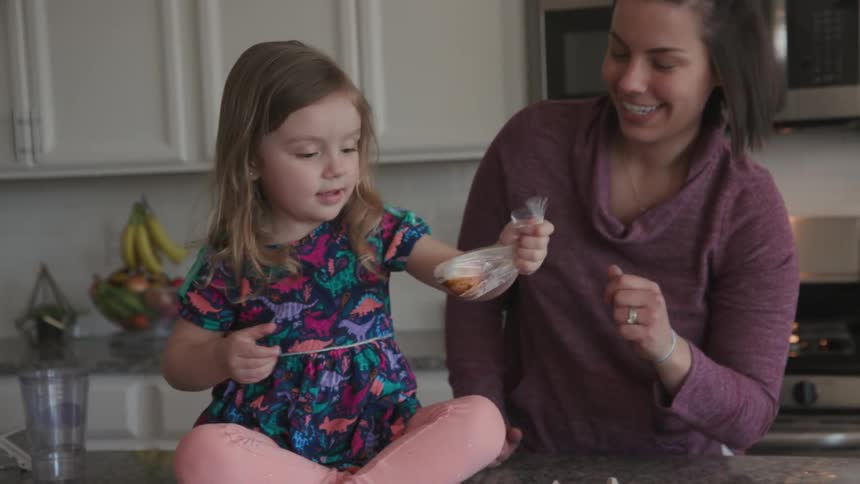 A girl dyes an egg by shaking it in a bag