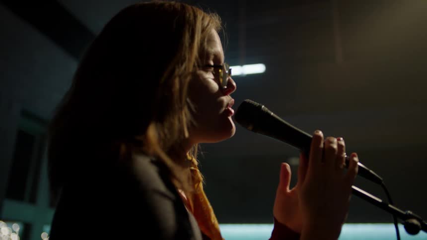 A woman is singing into the microphone