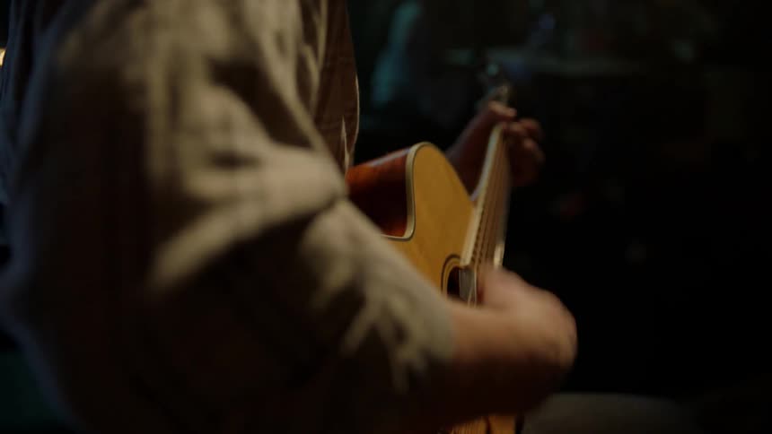 A man plays guitar in a bar