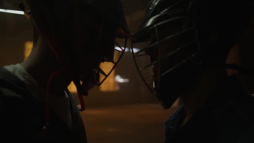 Two lacrosse players bump heads and push each other