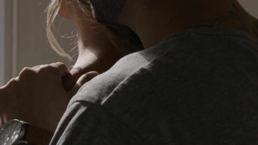 A man hugs a woman from behind