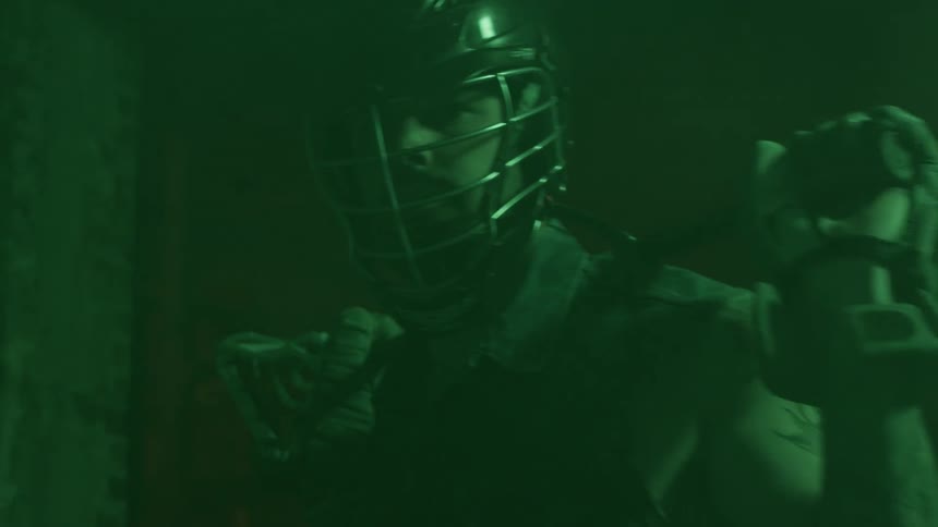 A man is standing with a lacrosse stick across his shoulders