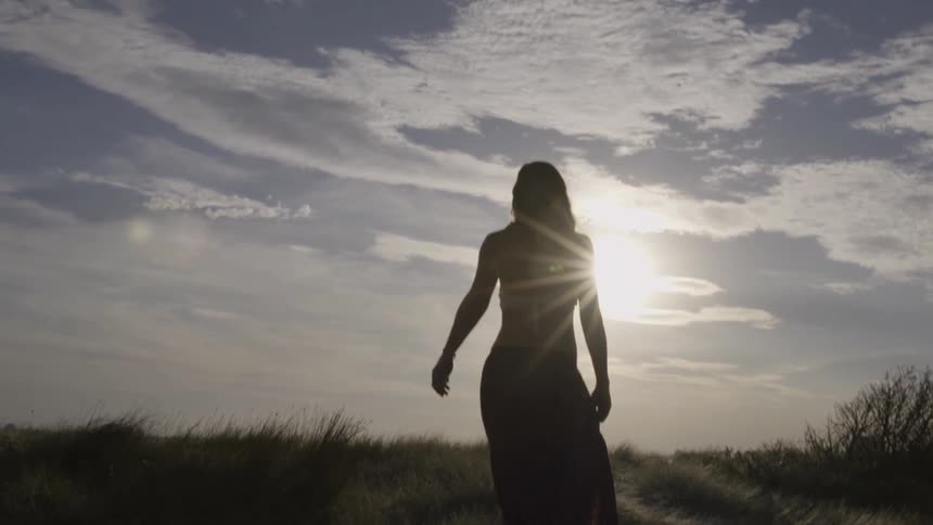 A woman walks on the beach on a sunny day