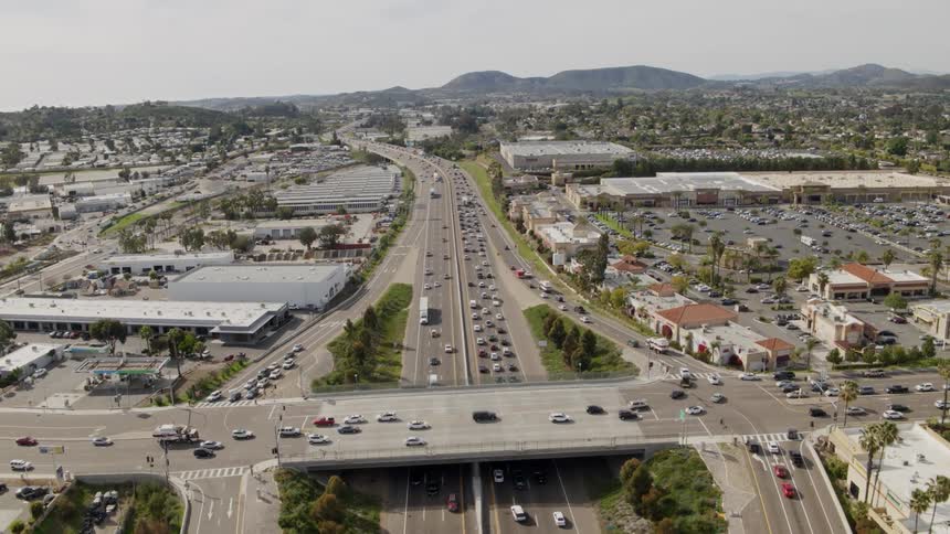 Overhead view of many cars driving down highways in a city