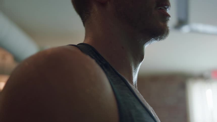 A man is standing in a gym sweating