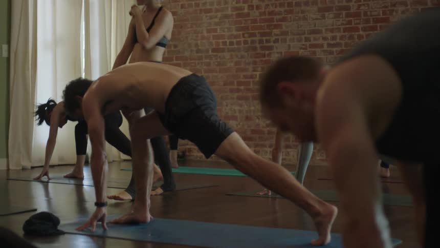Men and women stretching on yoga mats