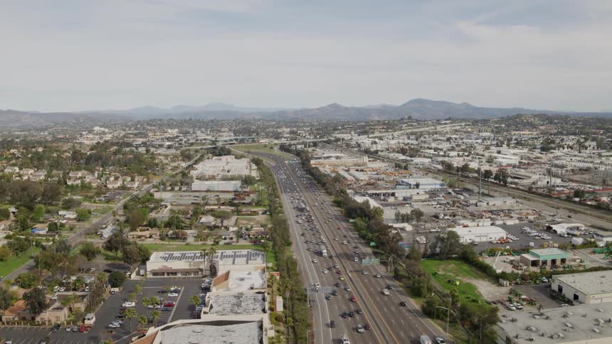 Traffic flows along a freeway and streets during the day