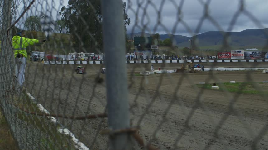Cars race on a dirt oval