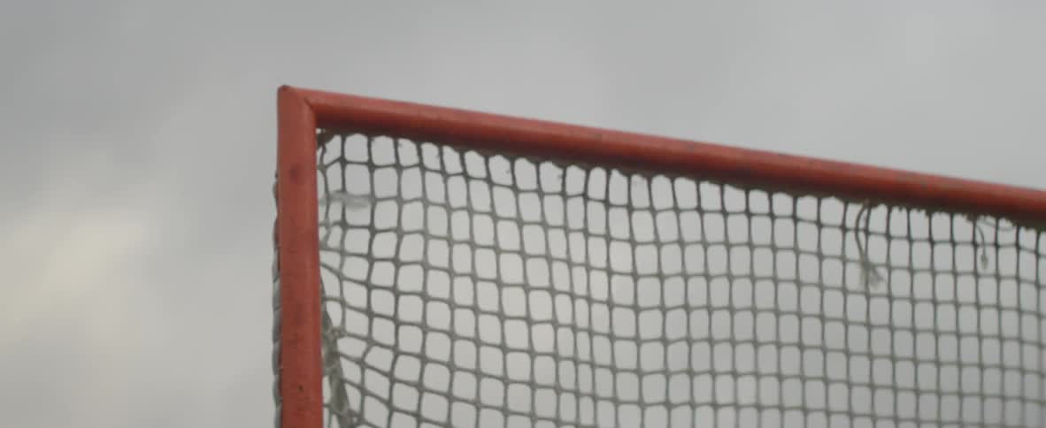 A goalie net moves as if a ball is hitting it
