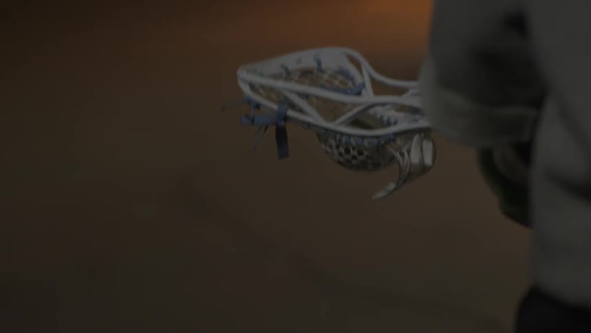 A player tosses a lacrosse ball up and down
