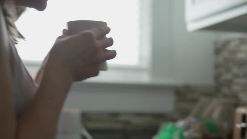A woman picks up her coffee cup