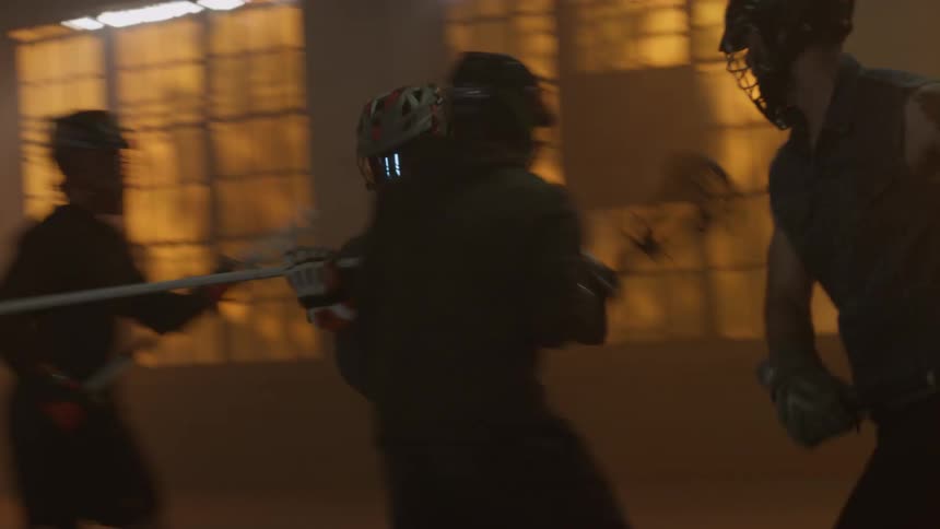 Group of people play lacrosse indoors