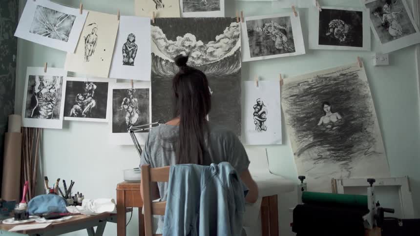 A woman sketches at her desk