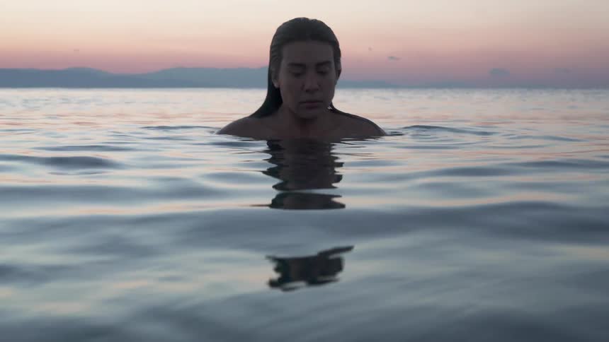 A woman floats in water with her eyes closed