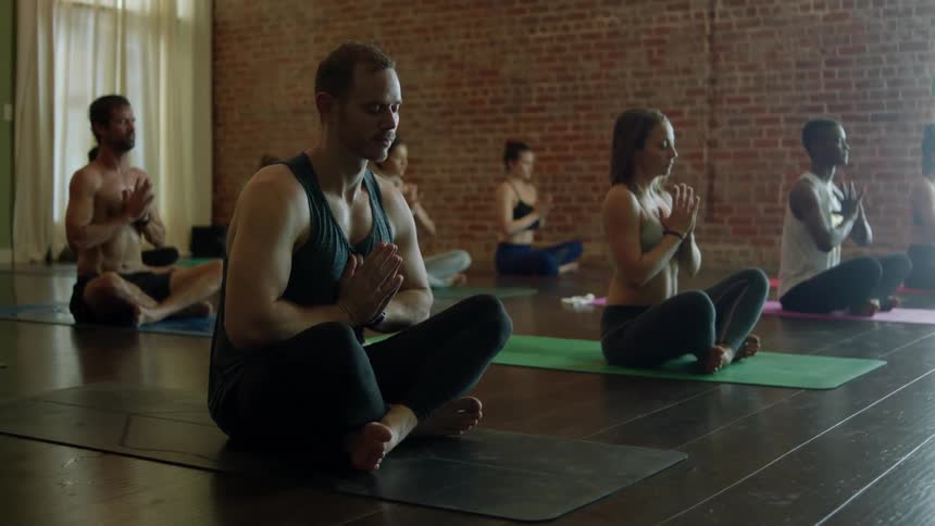 Men and women practicing meditating