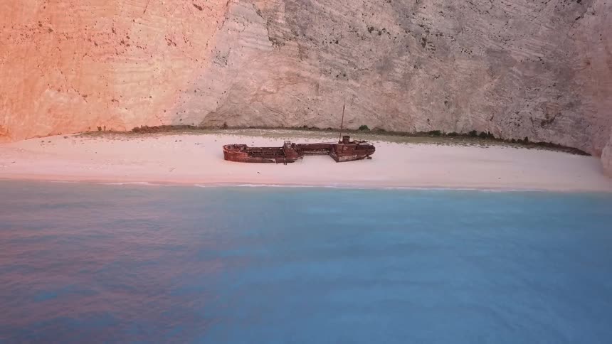Shipwrecked boat sits on the beach