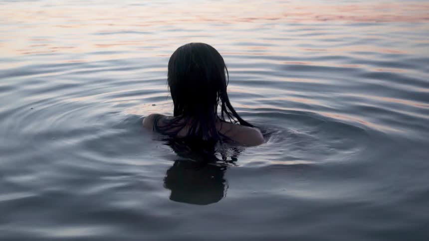 A woman is wading in the water