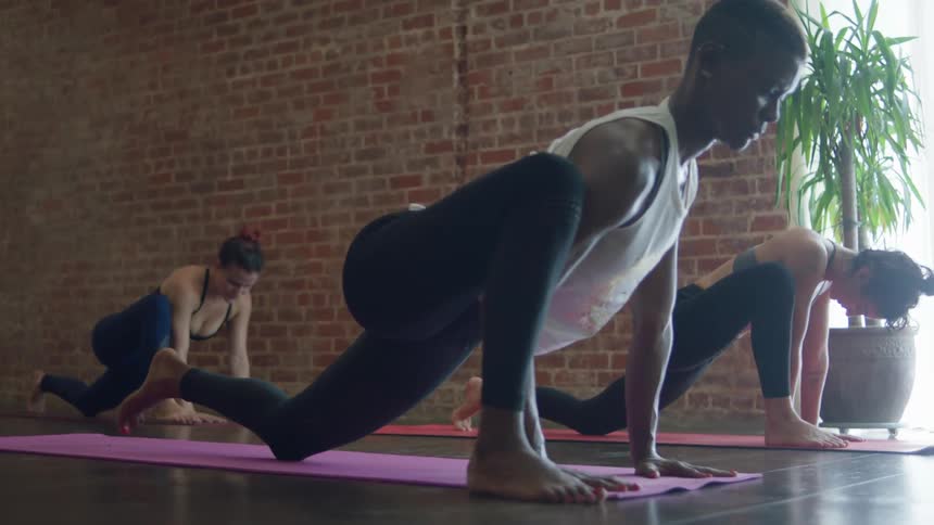 People on yoga mats lunge forward