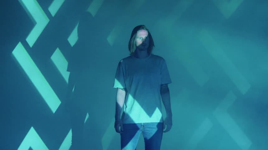 A man stands as strobe lights cover him
