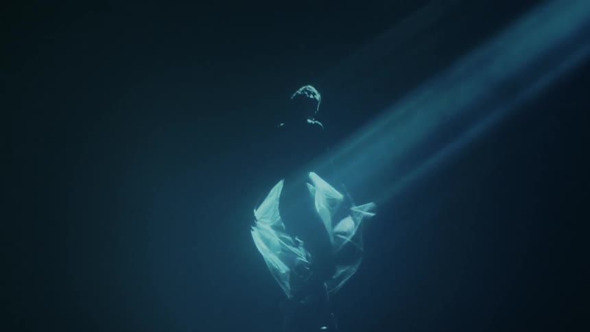 Woman dances with a spotlight shining on her