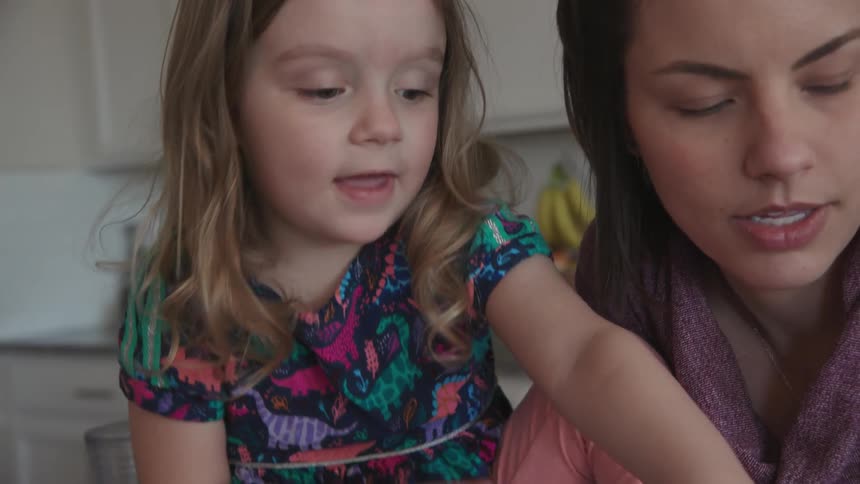 A child reaches over to pick up an egg