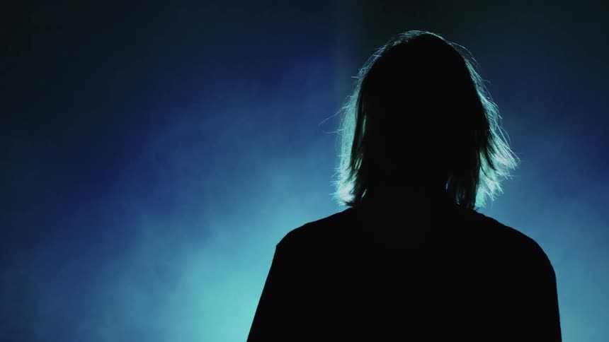 A person walks towards a strobe light