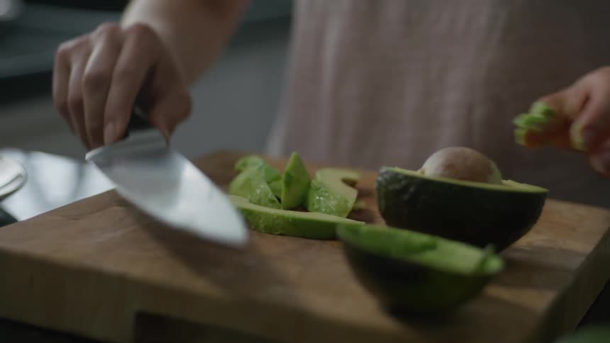 A woman is cutting up avocado