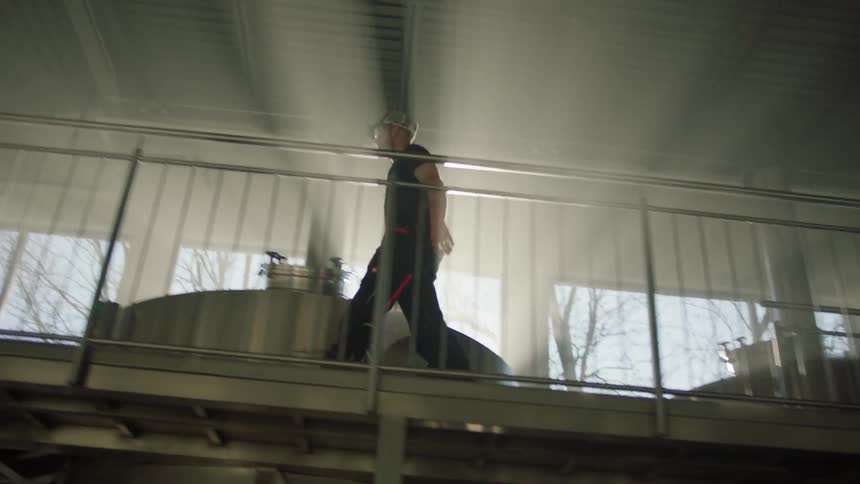 A man climbs the steps of a distillery