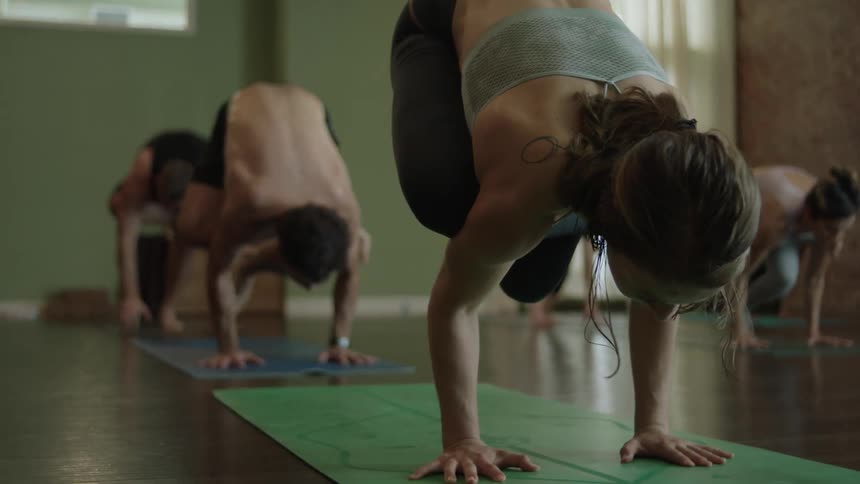 People doing yoga do a handstand together