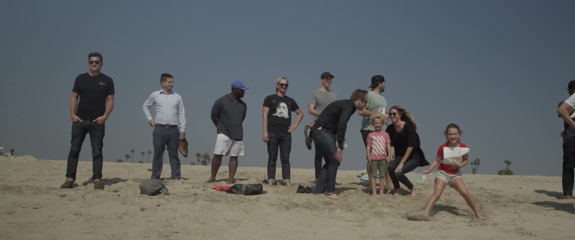 A group of people and children huddle on the beach