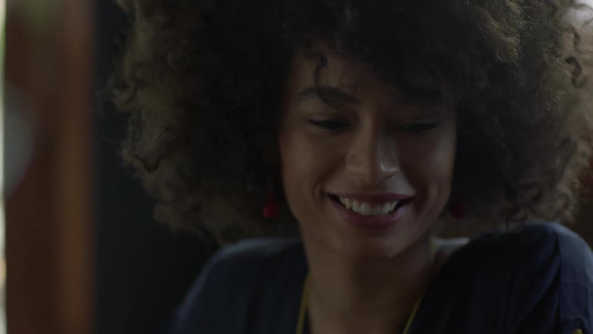 A woman smiles and looks over towards someone