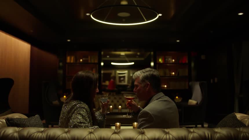 A man and woman enjoy cocktails in a bar