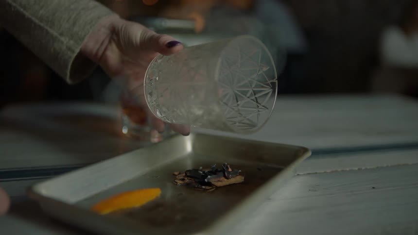 A woman flips over an empty glass in a restaurant