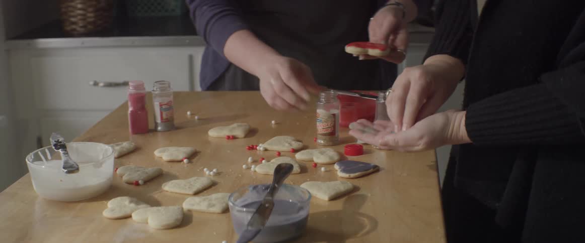 Two women decorate cookies together
