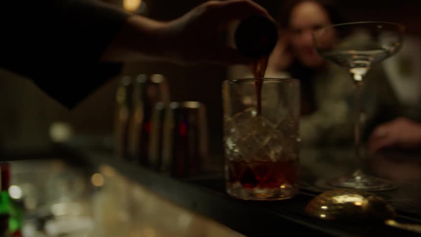 A bartender makes a drink
