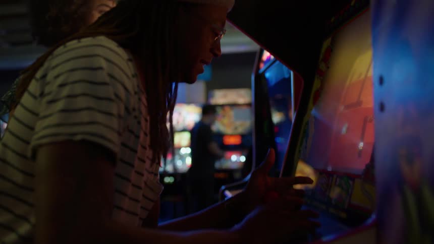 The arcade is full of people playing different machines