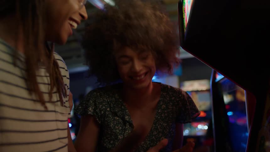 A man and woman play an arcade game