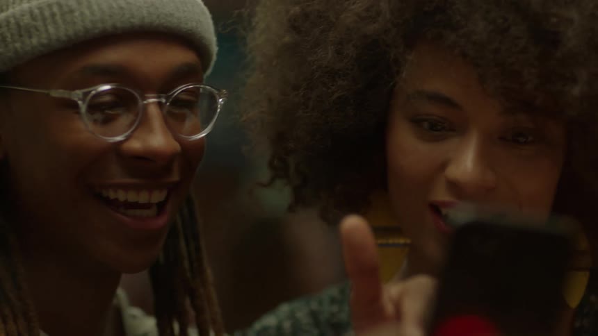 Two people are looking at a phone talking