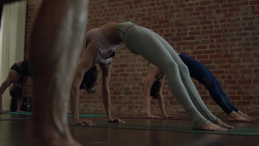 Several people are bending backwards stretching in an exercise class