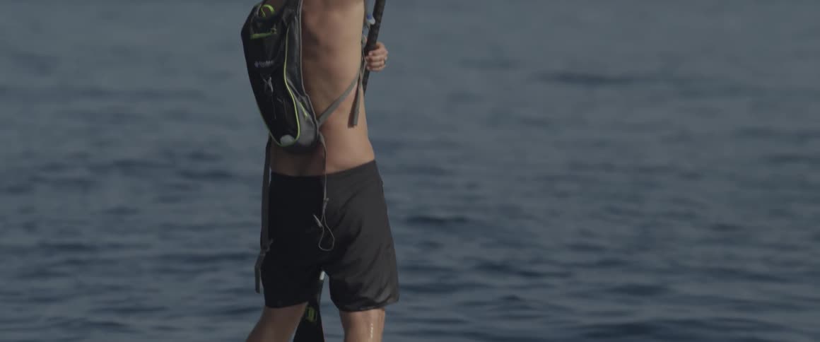 A man paddles on a board in the ocean