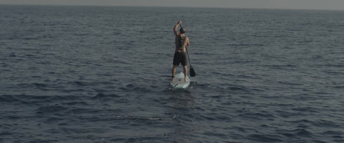 A man paddles on a surf board