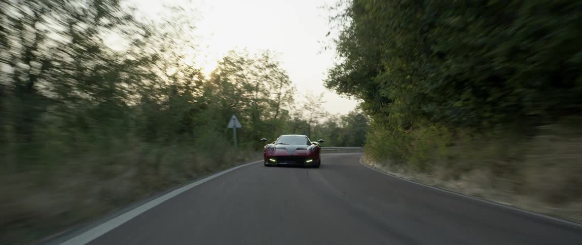 A sports car speeds along a country road