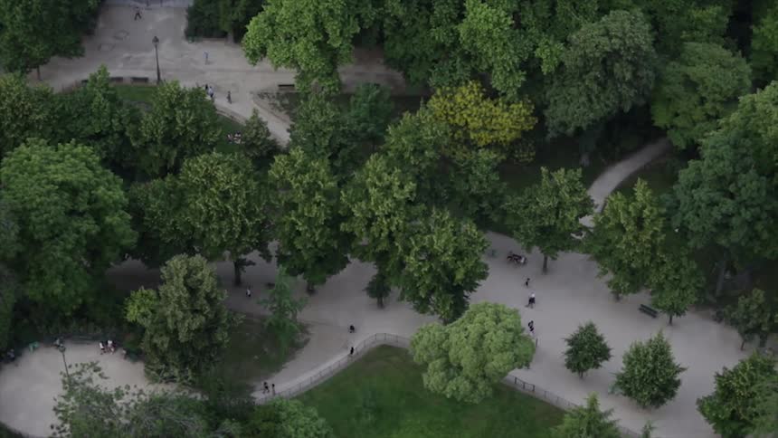 People walk on wide pathways in a park