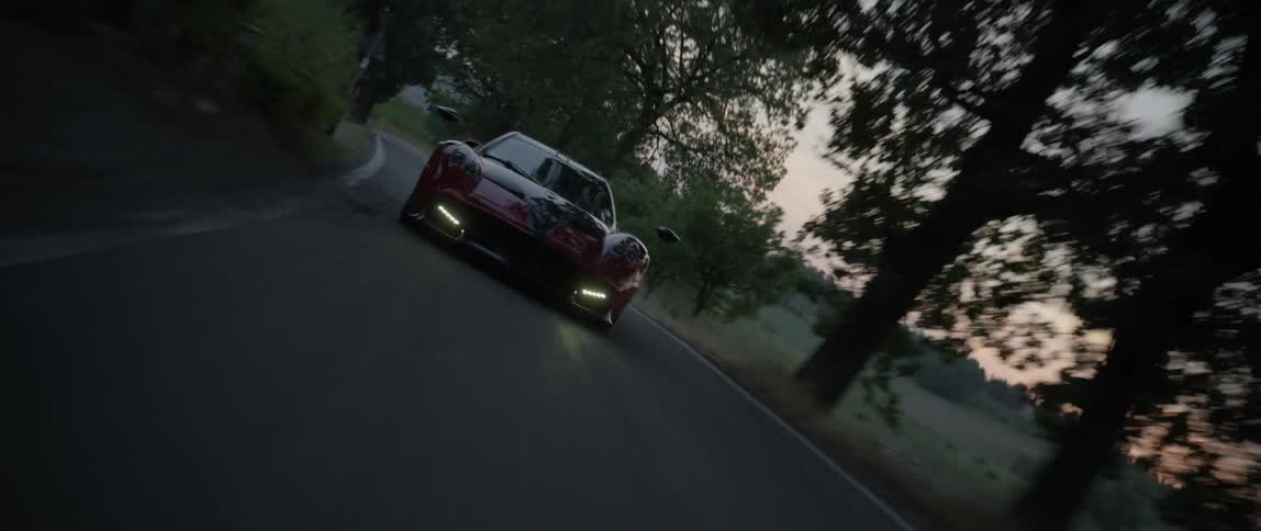 A sports car speeds along a country road