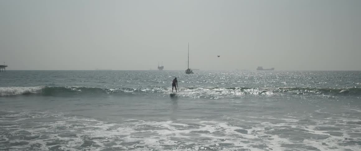 A man paddles on a board in the ocean